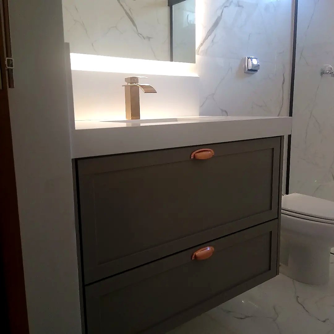 Gabinete de banheiro cinza com puxadores cobre